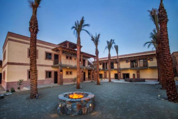 center at night with firepit in the middle and palm trees around