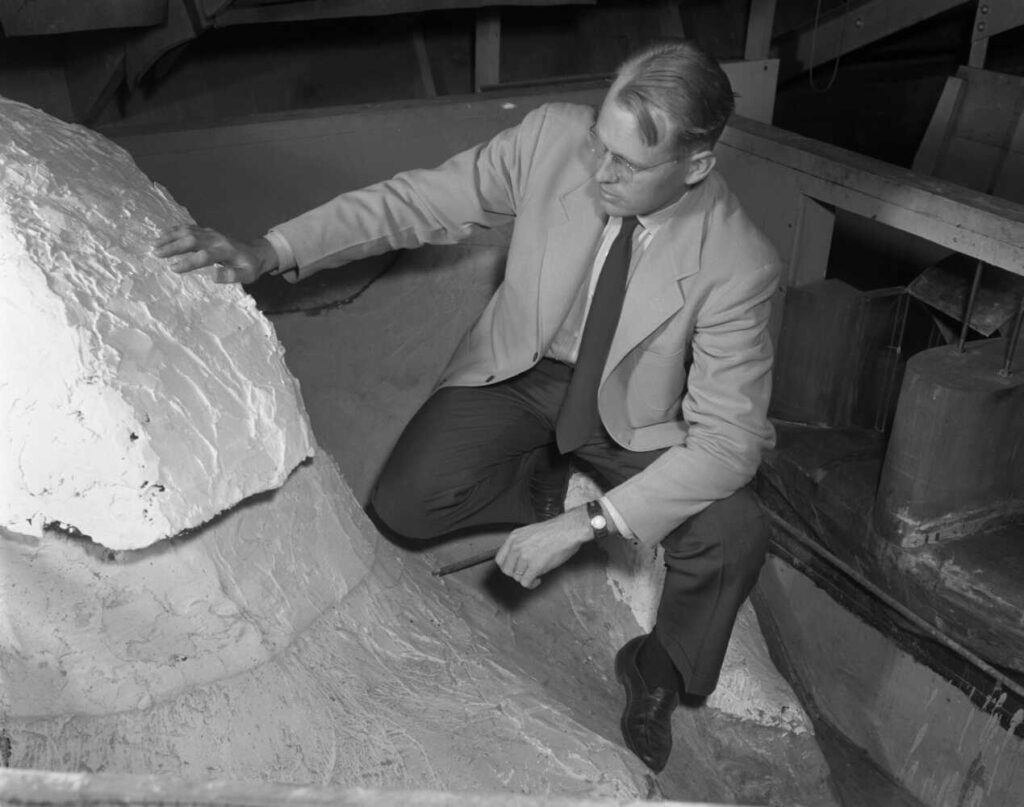 Maurice “Maury” Albertson crouching down to examine a structure