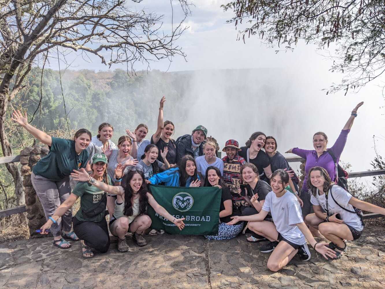 10+ csu students smile in front of a large waterfall