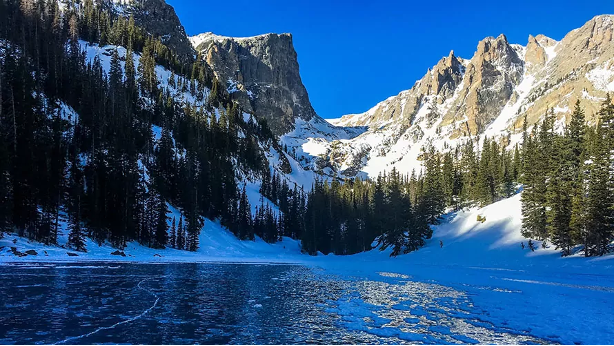 Snowcapped mountains behind an icy lake