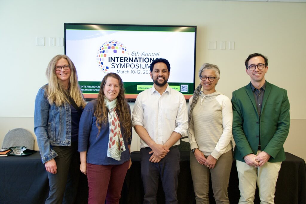 A group of panelists pose together at the 2025 International Symposium