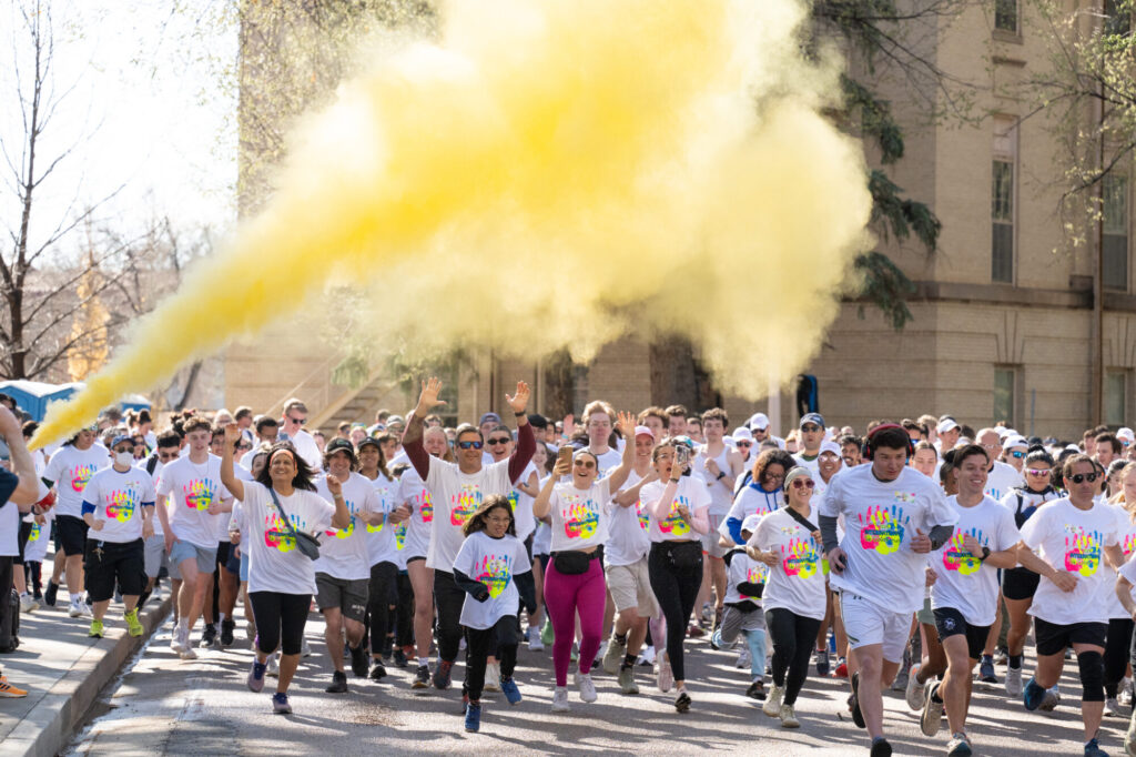 Yellow color powder sprays into the air as a group of runners start a race