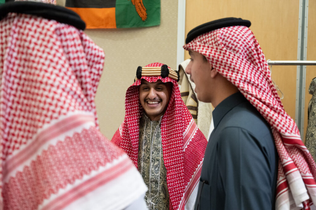 Students laughing while wearing traditional dress
