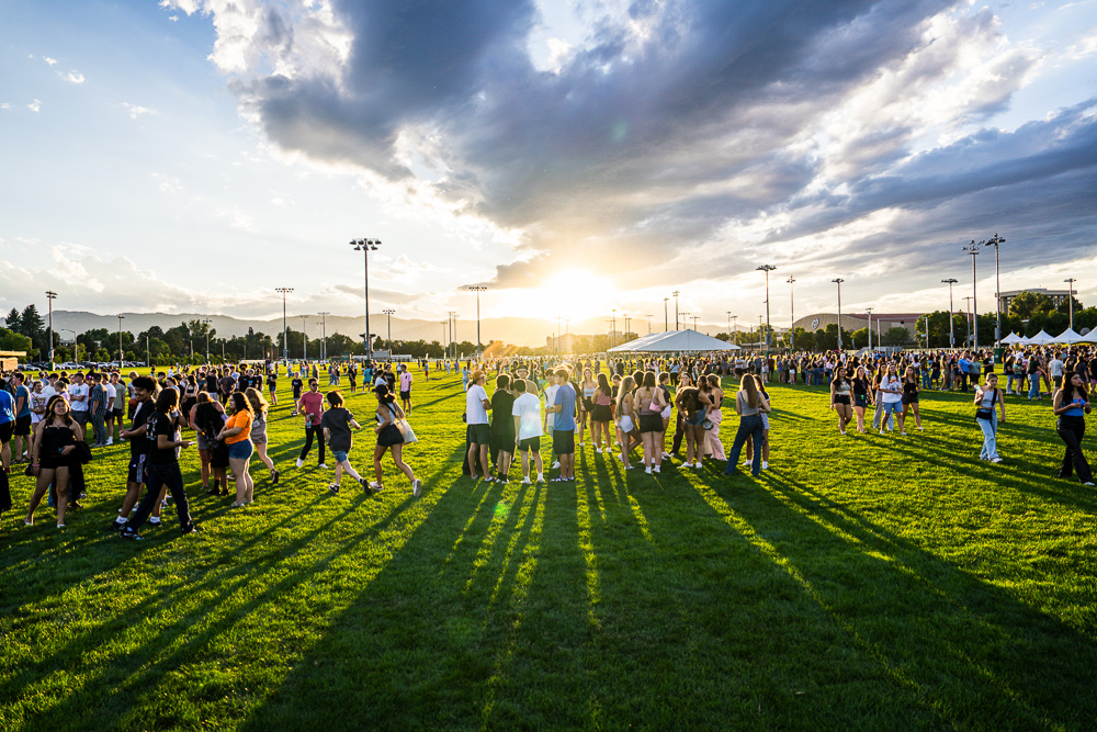 A large event with many people on a big grassy lawn.