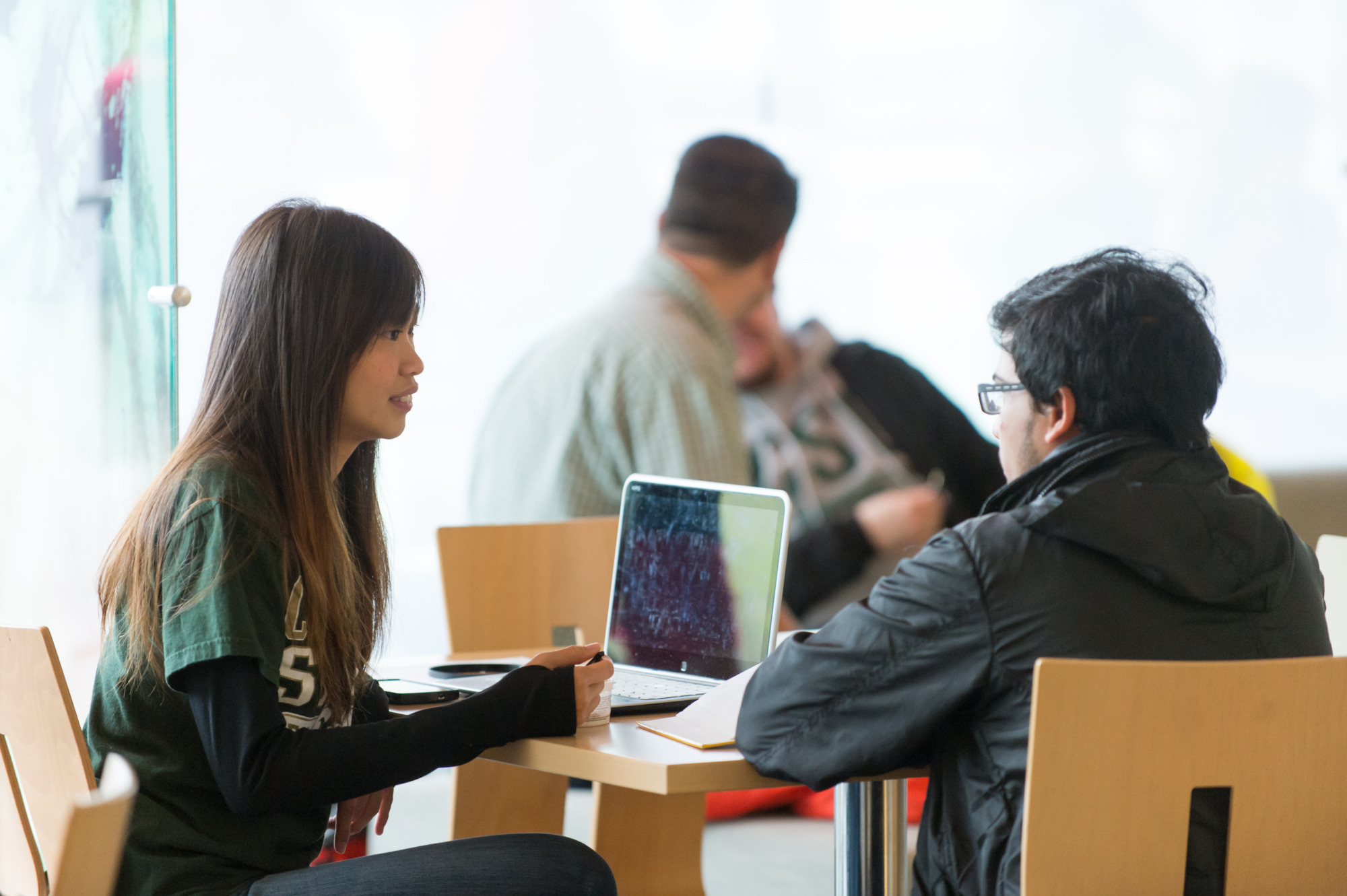two students talking by a computer
