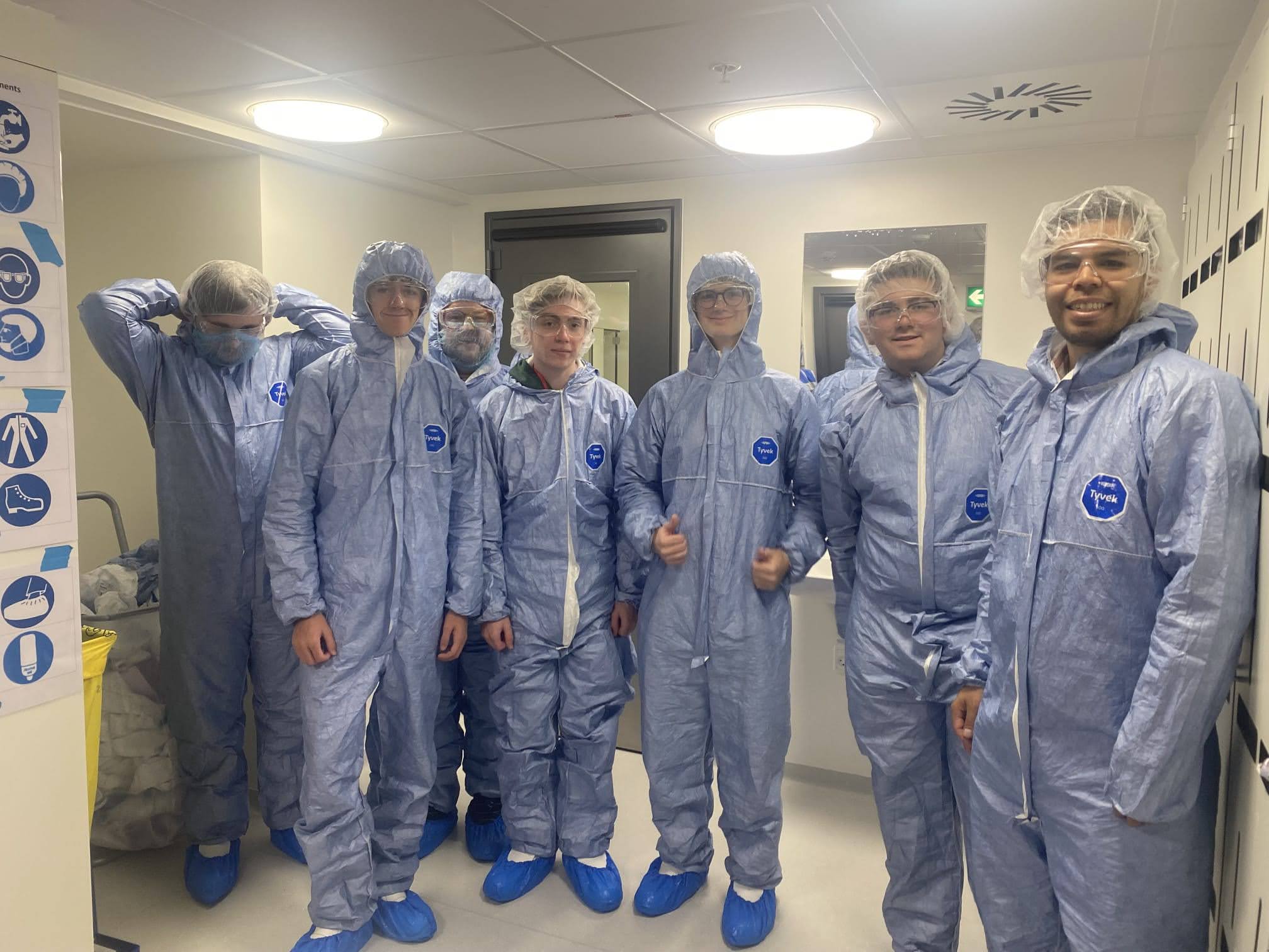 A group of students wearing hazmat suits in a lab