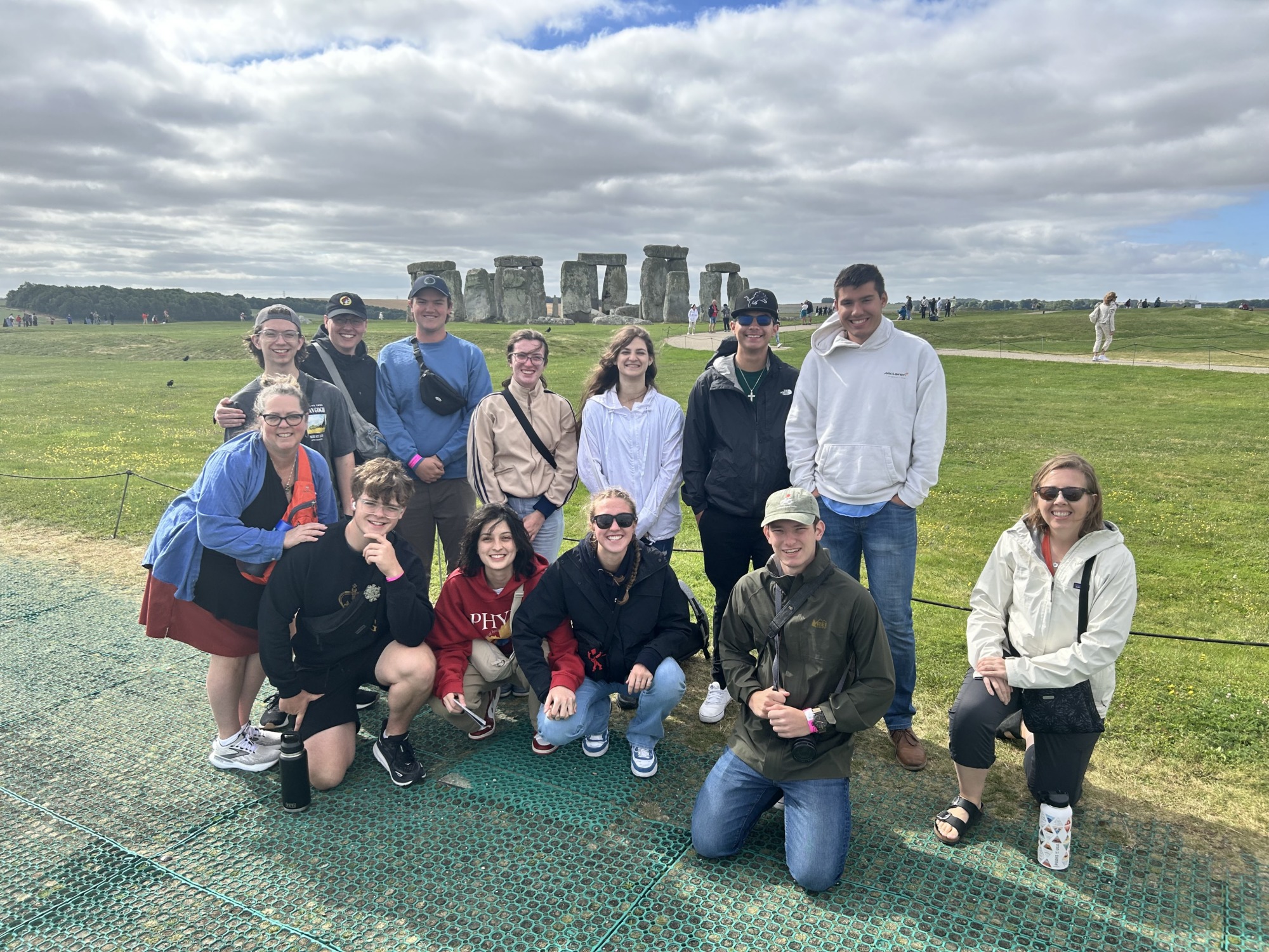 A group posing in front of the stonehenge rocks