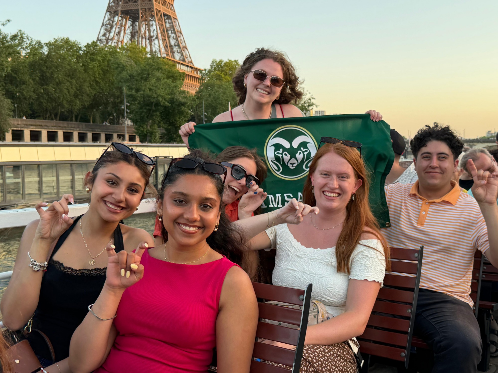 A group of students on a river tour with the eiffel tower in the background