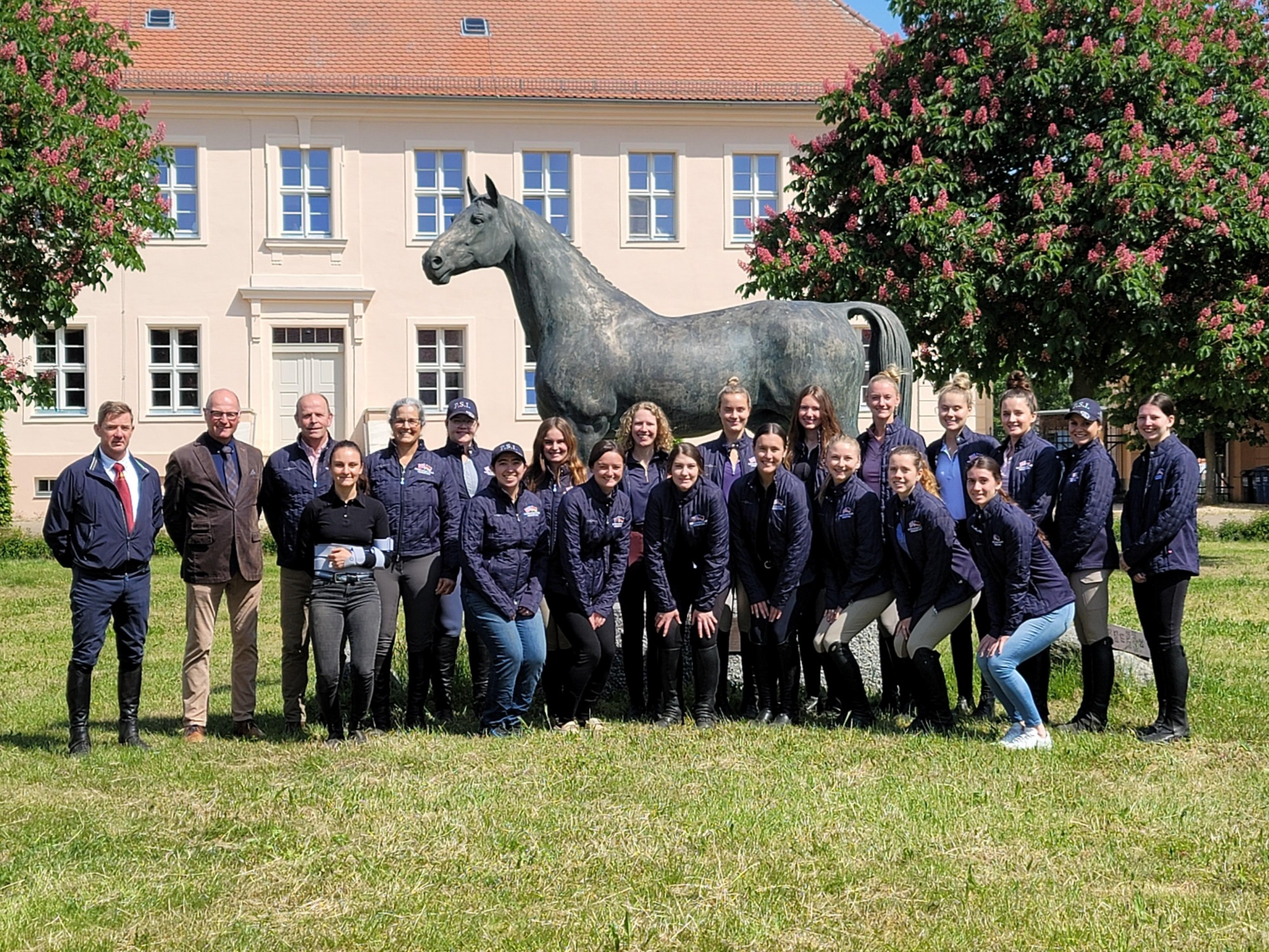 A group of students in front of a statue horse