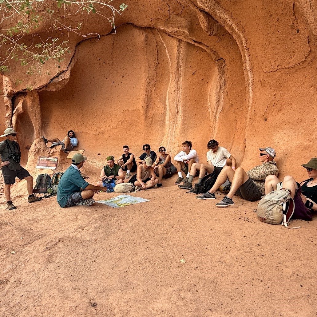 A group gathers around a map in a cave