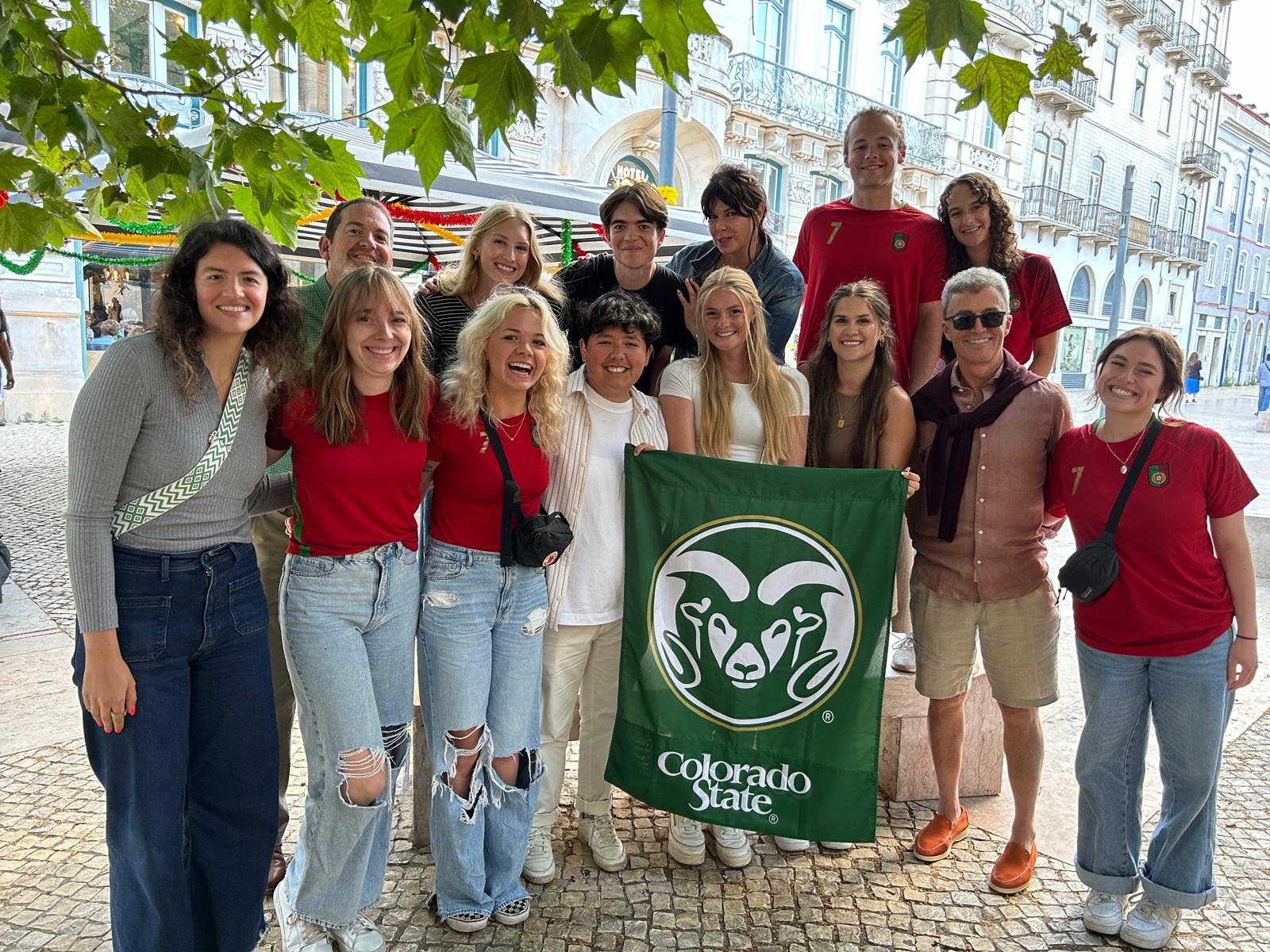 A group of students holding a CSU green flag