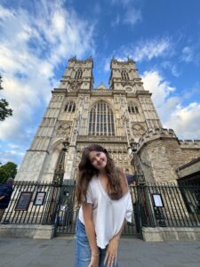 student posing in front of an old church or castle