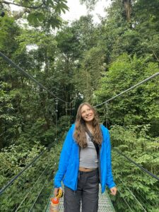 student standing in front of a woodland background