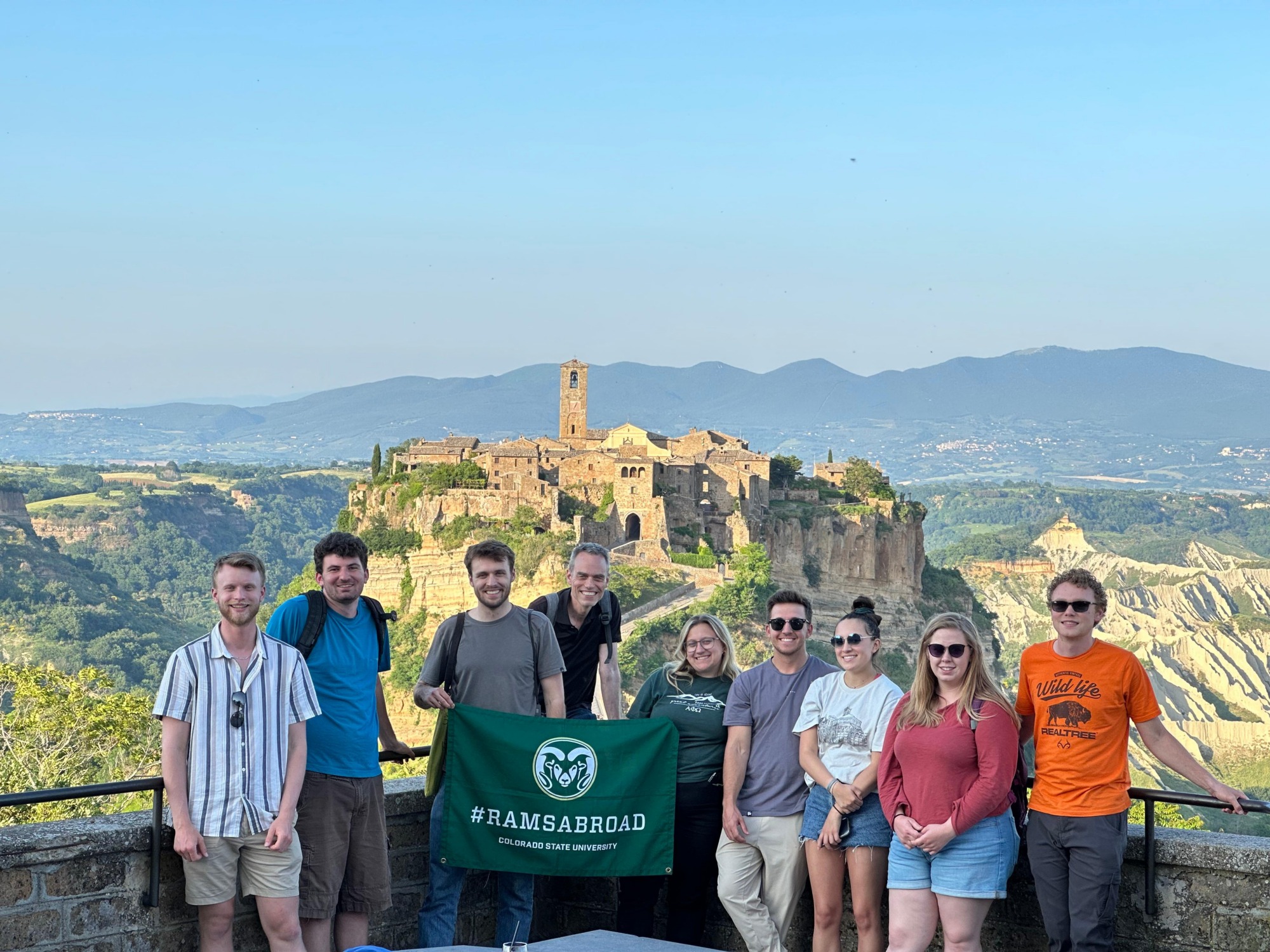 A group of students overlooking a vista holding a ramsabroad flag