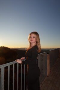 A student stands at a balcony at dusk