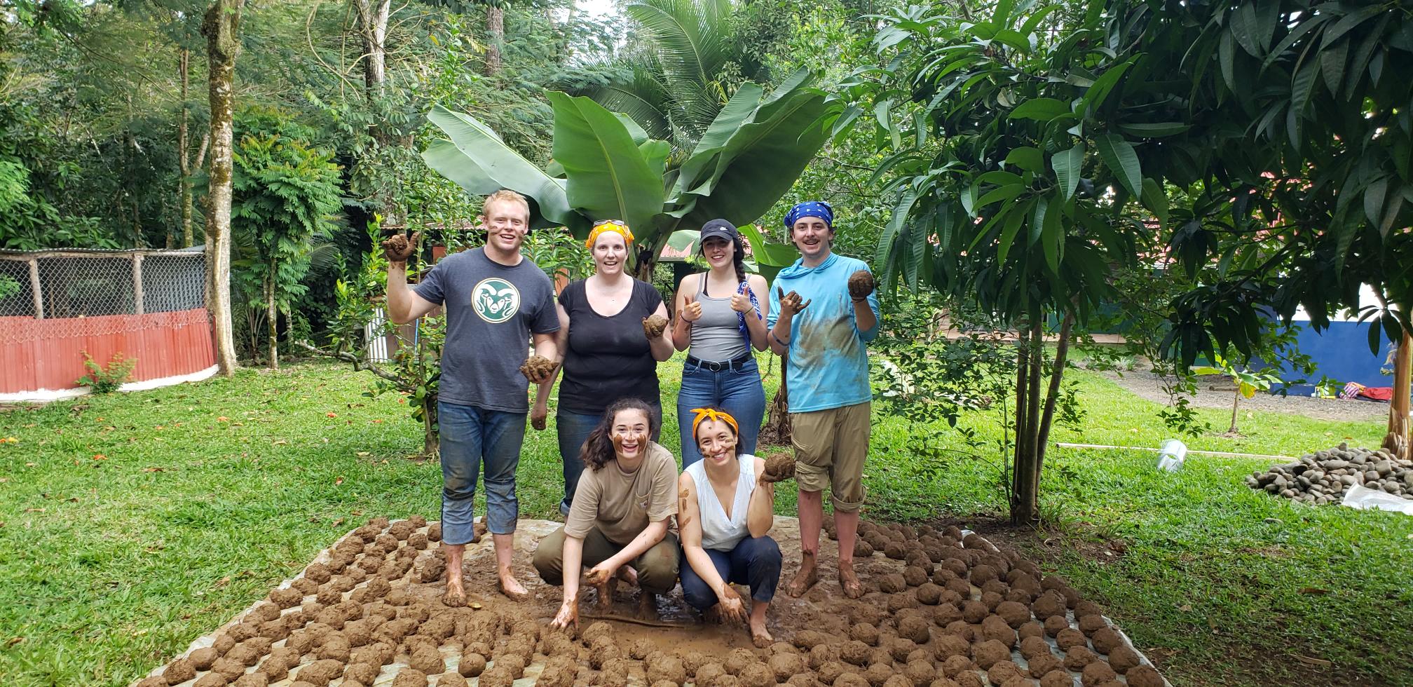 A group of students in the mud in a tropical environment