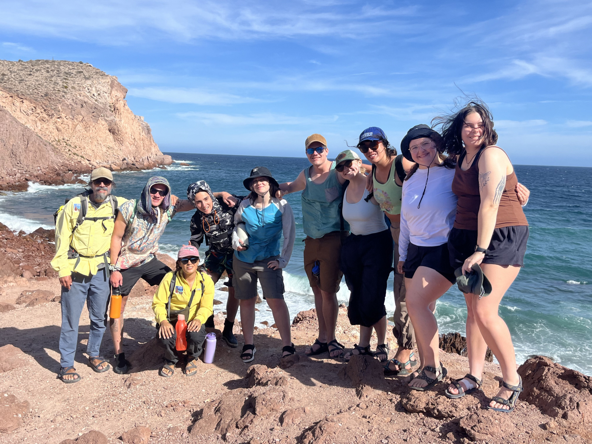 A group poses by the ocean