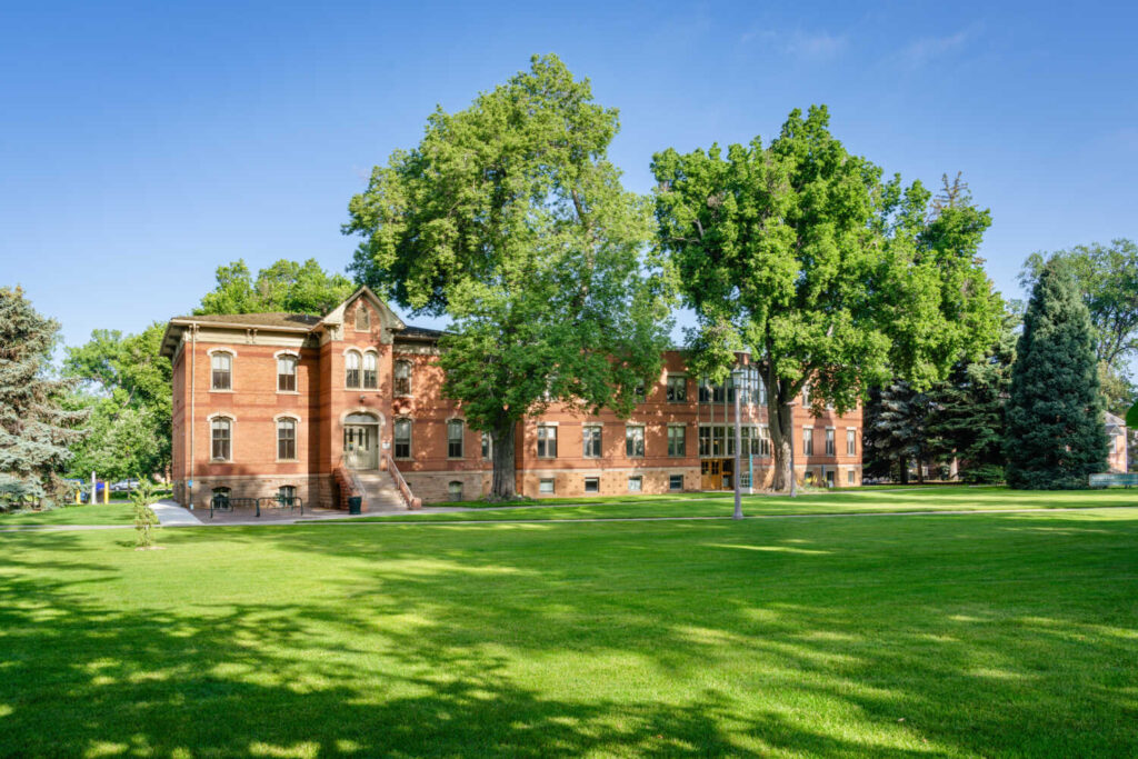 A brick building from the outside on a green lawn.